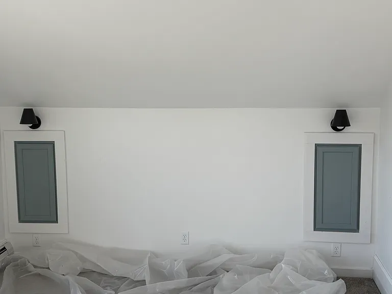 Towards bed. Lights for reading. Cupboard for stowing items. Three electrical outlets - one on each side of the bed and one at the head of the bed