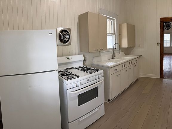 Comfortable kitchen with gas stove, metal cabinets and farmhouse sink. Lots of natural light.