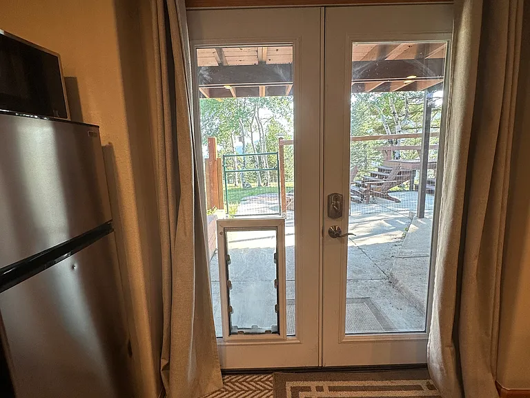 dog door incorporated in glass has heavy duty metal cover that seals out the cold