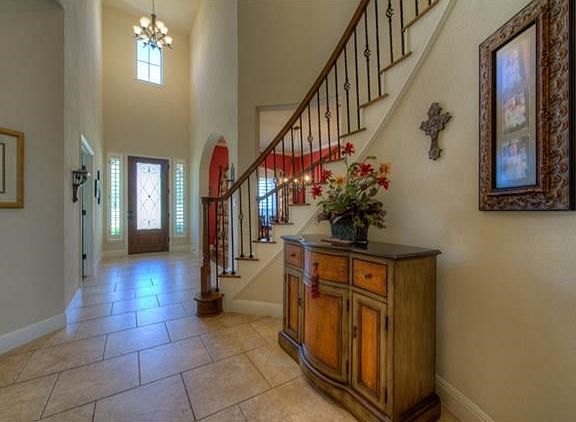 Exquisite foyer with wrought iron and wood front door.