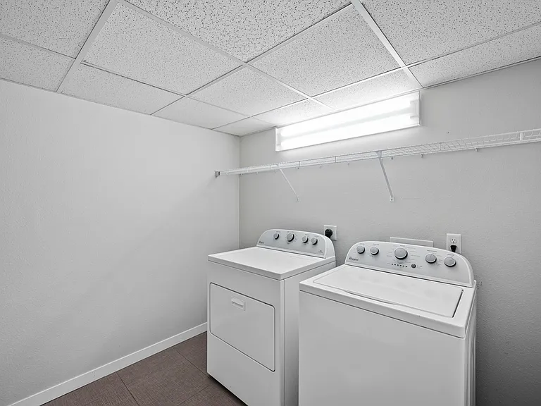 Modern laundry room with high-efficiency washer and dryer, bright lighting, and ample storage space. Modern laundry room with high-efficiency washer and dryer, bright lighting, and ample storage space.