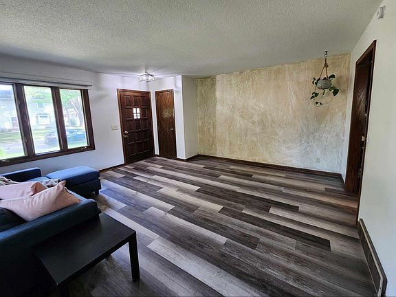 Living room at the front of house with coat closet, crank out windows in front and a sliding window on side.