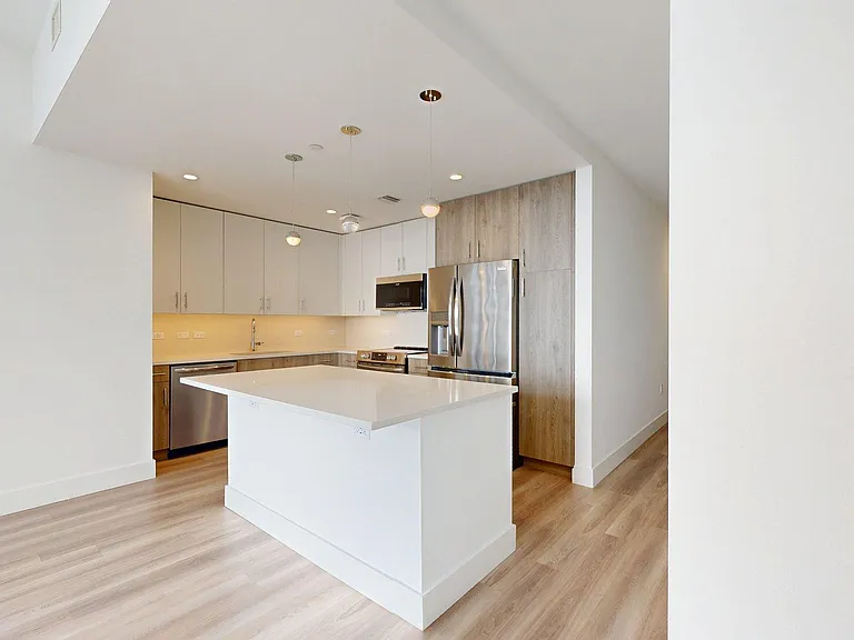 Apartment Kitchen with Stainless Steel Appliances, Quartz Countertops and Wood-Style Flooring