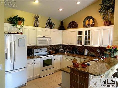 Remodeled kitchen with granite counters and raised panel doors.