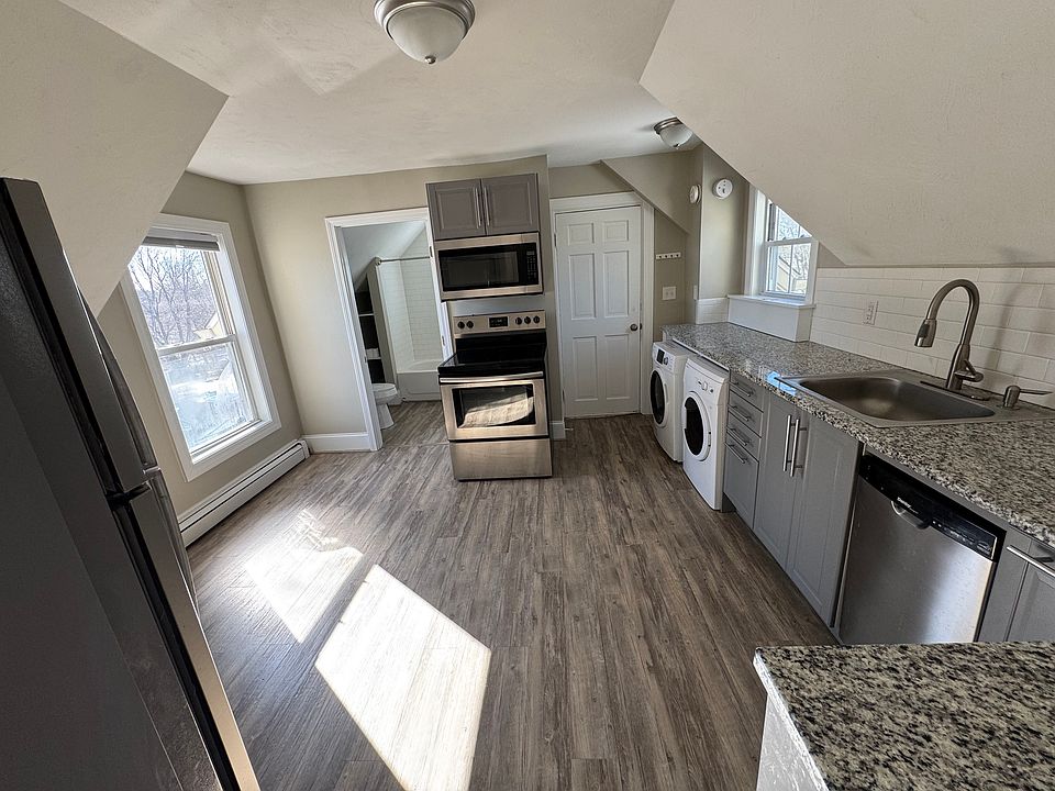 View of kitchen from living room, entrance to the unit is the door to the right of the stove, bathroom is to left of the stove.