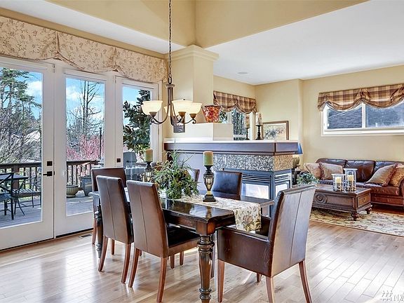 Dining area with double sided gas fireplace and French doors to the deck.