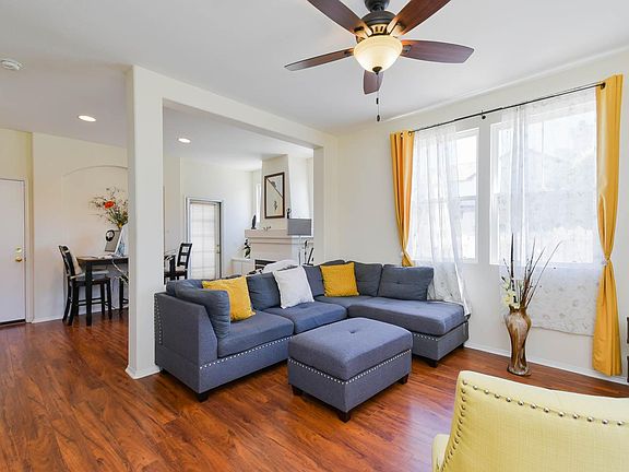 The sun filled living room with beautiful floor. The dining room is behind with fireplace.