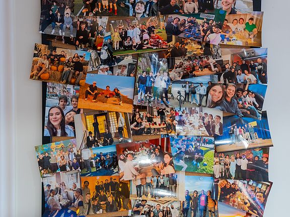 Photo board full of pictures of the house mates hanging out.