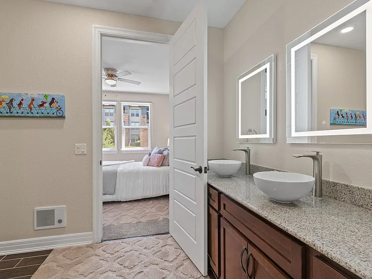 Dual vanities with vessel bowl sinks and LED backlit mirrors