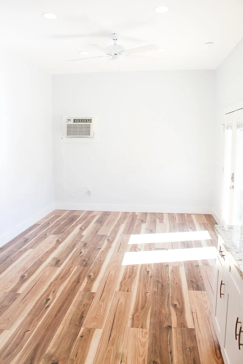 Gorgeous hardwood flooring stands out in the natural lighting and neutral wall colors. Large living area with ceiling fan and window ac/heater unit. - 5509 Hillman St