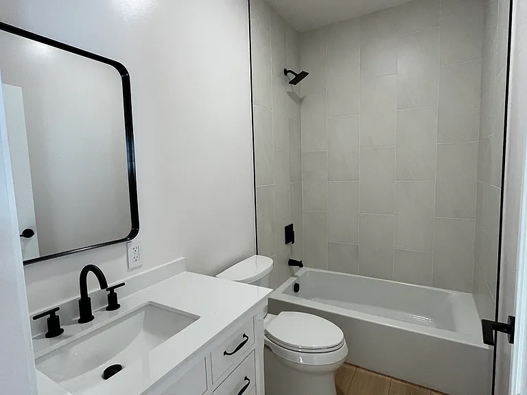 Fully tiled bathroom with updated vanity.