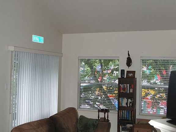 Living room features vaulted ceiling, skylight and balcony