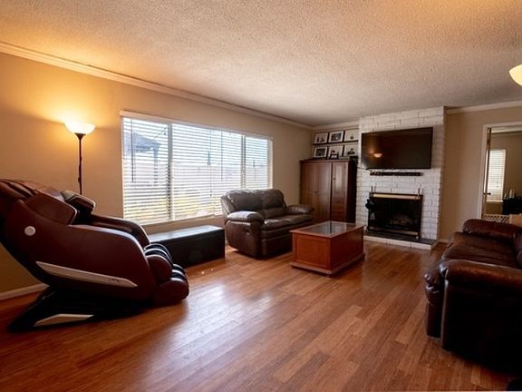 Large living room features wood burning fireplace.