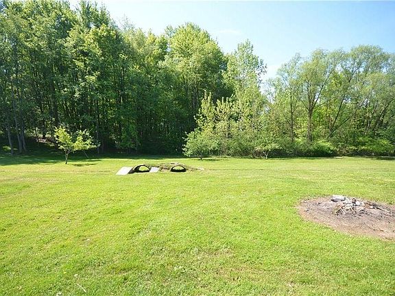 Unfenced portion of yard with bike jump and bike path into the wooded area