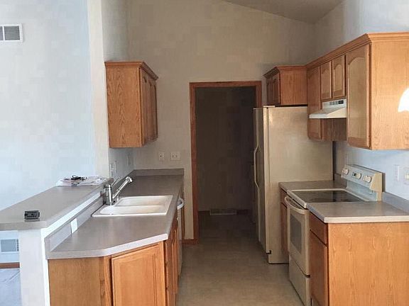 Walk-thru galley kitchen adjacent to in-unit laundry with po