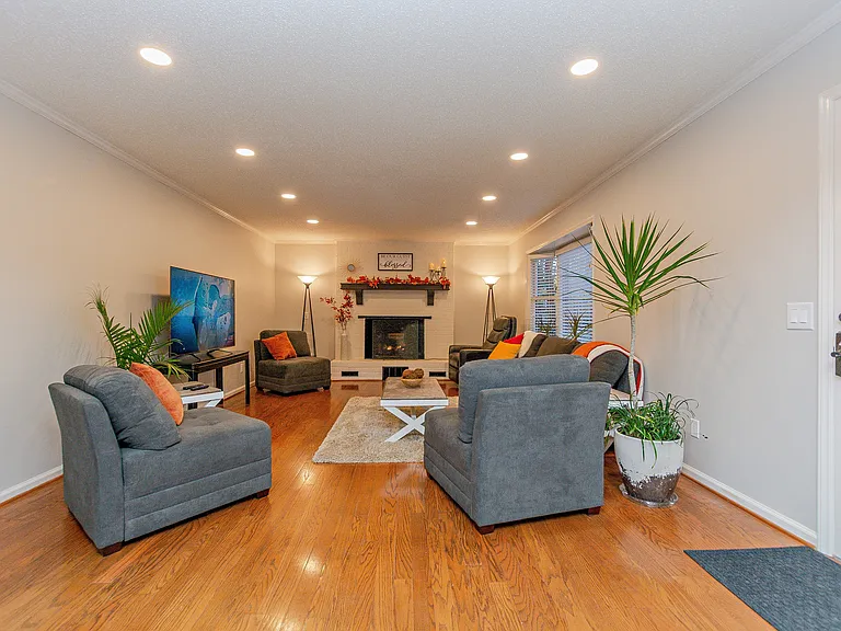 Living room with fireplace at the end and big screen TV.
