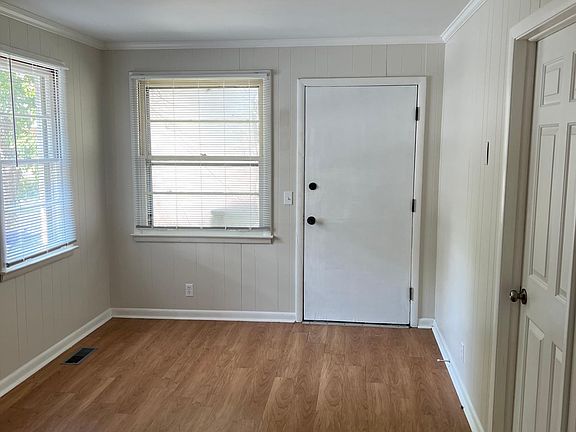 View at the kitchen's entry towards the living room, front door, and front bedroom.