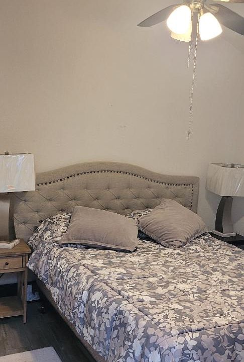 bedroom with full bed, night tables and small tv stand with tv
