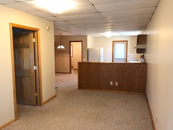 Living room, kitchen, entrance to bedroom on left