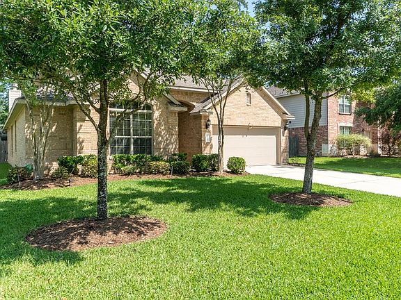Yard features beautiful trees and a sprinkler system.