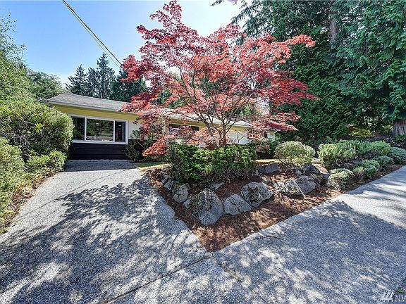 View of the front of the home from the second driveway, which slopes upward and will fit larger vehicles (e.g. trucks).