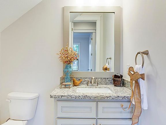 First floor powder bath with granite counter and framed mirror