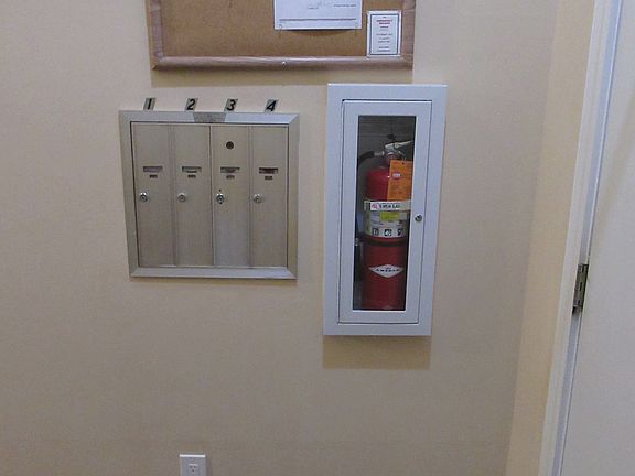 Main Lobby: Mailboxes, Bulletin Board (General Notices & 24 hr Owner Contact number), & 1st Floor Fire Extinguisher