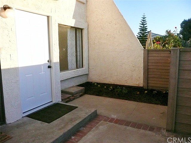 Large private fenced patio with both brick-ribboned concrete and a garden area perfect for plants or grass.