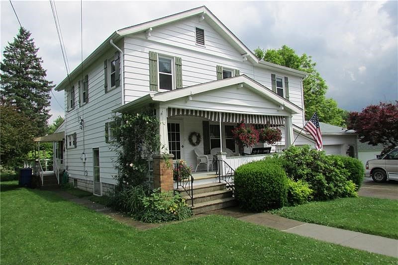 Exterior front with covered front porch 2 car garage. Back wrap around deck with benches.