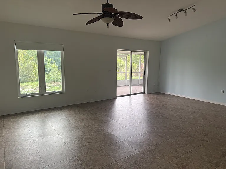 Spacious living room with access to screened-in patio.