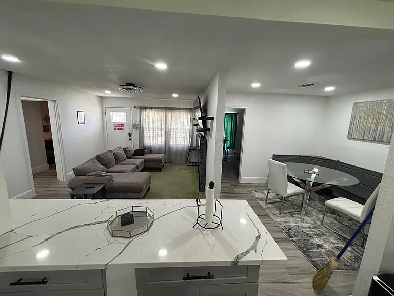 Open-concept living and dining area with sectional seating, recessed lighting, and space for a breakfast nook.
