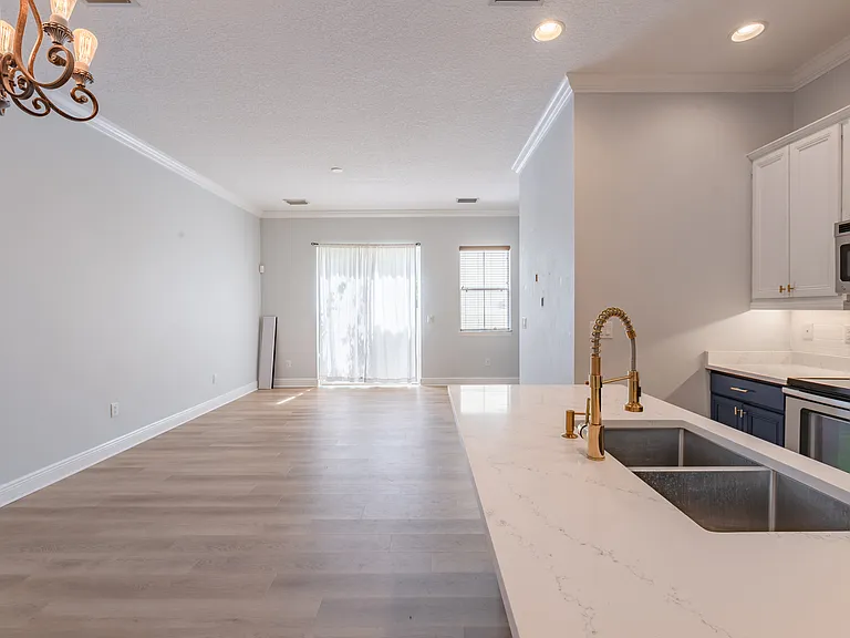 The kitchen and living area have plenty of natural light. Here, you can see the sliding glass doors leading you to the partially fenced-in turf yard.