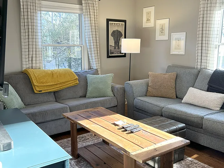 Cozy living room with two couches, ottoman and a coffee table.