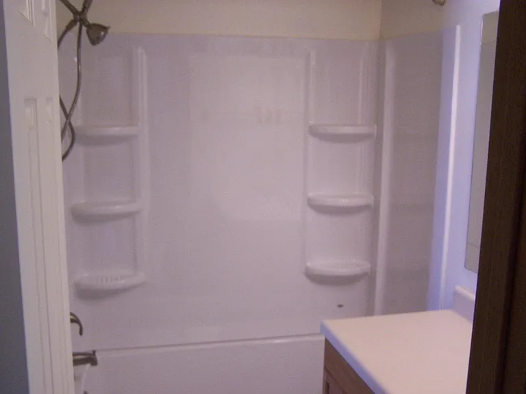 New shower, tub surround with curved bar, dual spray heads.