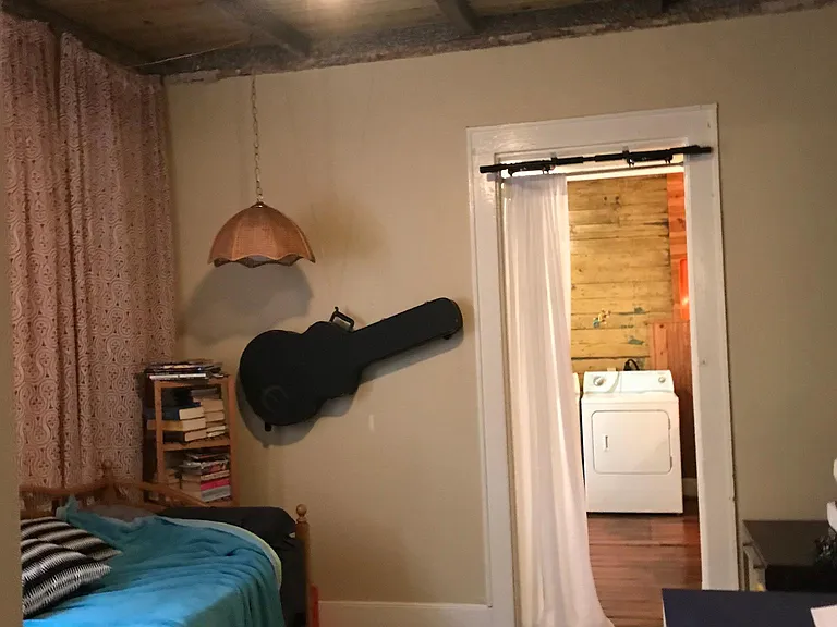 Second bedroom with exposed beams leading to kitchen