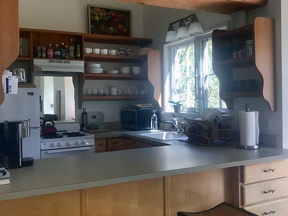 Bar counter looking into kitchen from dining room, pine slab shelf, open custom fir shelfs.