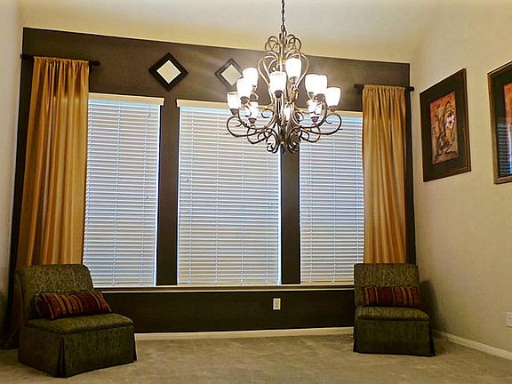 Dining room with custom light fixture, window treatments, high ceilings