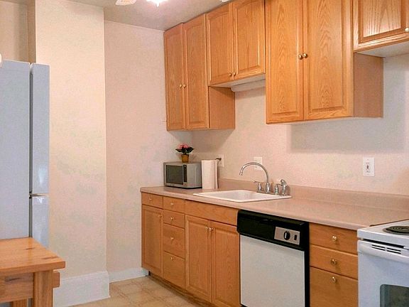 Large kitchen has new appliances and a stack washer and dryer.