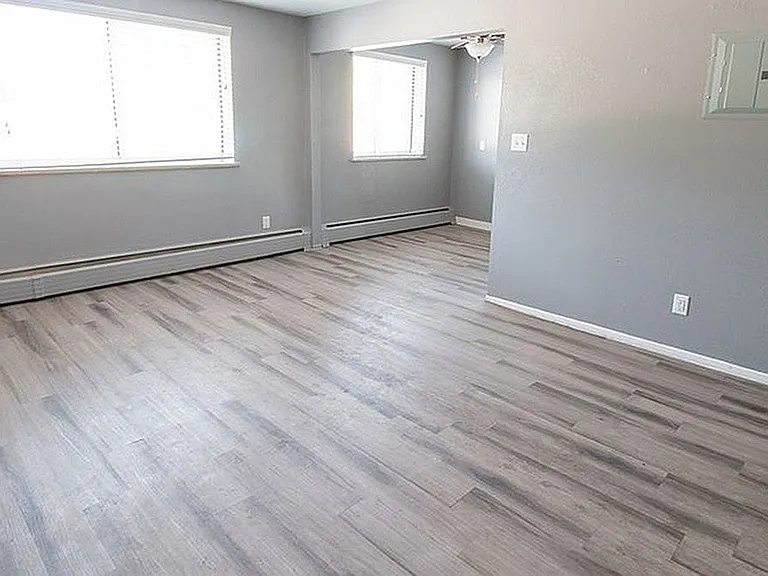 Modern apartment interior with sleek gray walls, expansive windows, and elegant hardwood flooring, perfect for a cozy and inviting atmosphere.