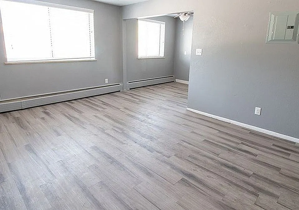 Modern apartment interior with sleek gray walls, expansive windows, and elegant hardwood flooring, perfect for a cozy and inviting atmosphere.