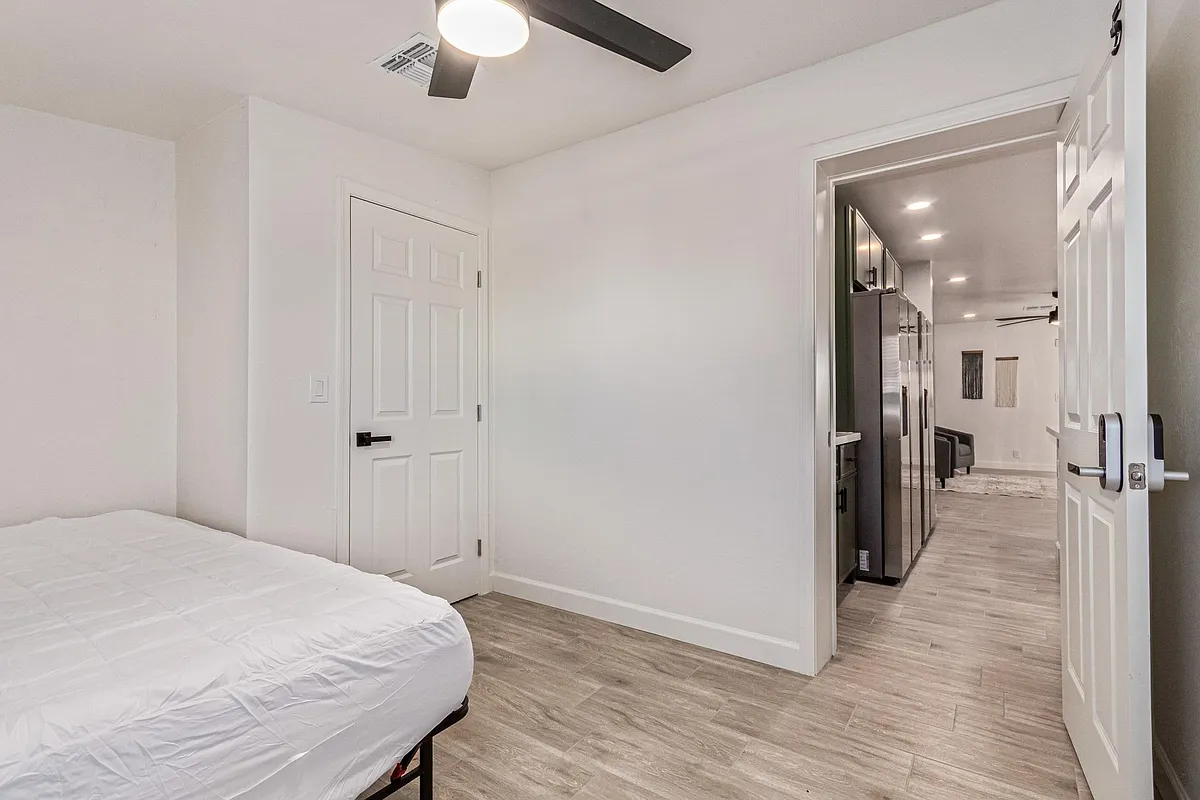 Queen bed, Closet with Desk and Chair and ceiling fan. Bedding and rug virtually staged. - W 2nd Pl
