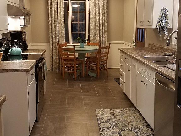 Newly updated kitchen with stainless steel appliances, ample storage including pantry, and balcony access