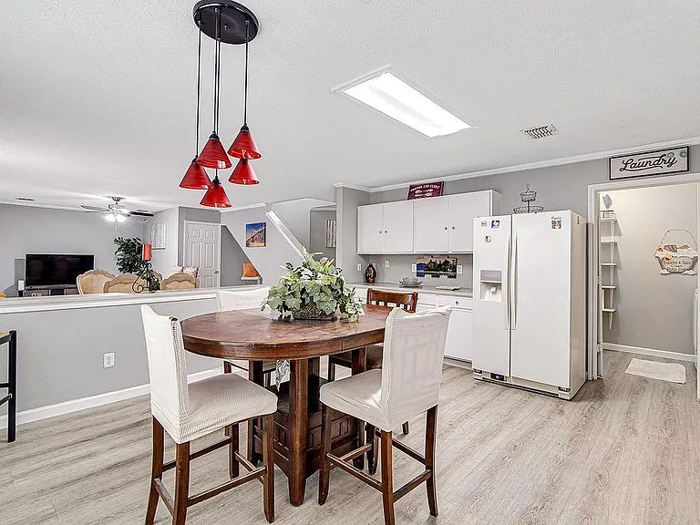 Open dining area with a pub-height table, convenient pass-through to the kitchen, and nearby laundry access.