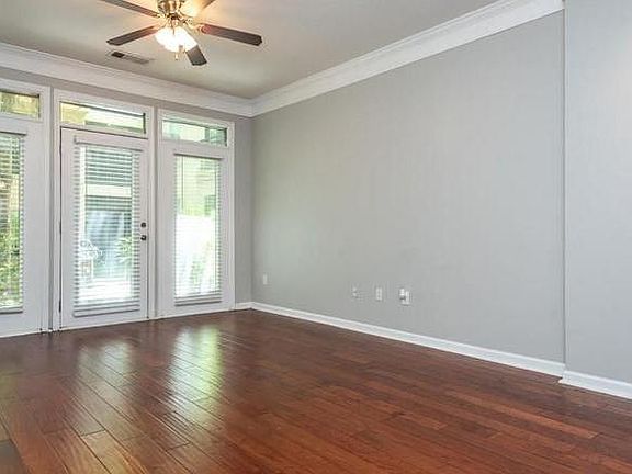 Living room without the furniture. Lots of natural light. Door opens to beautiful courtyard with a gas grill.
