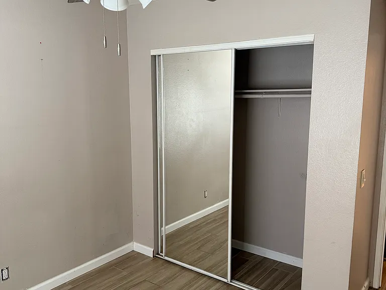 Guest bedroom with mirrored closet doors.