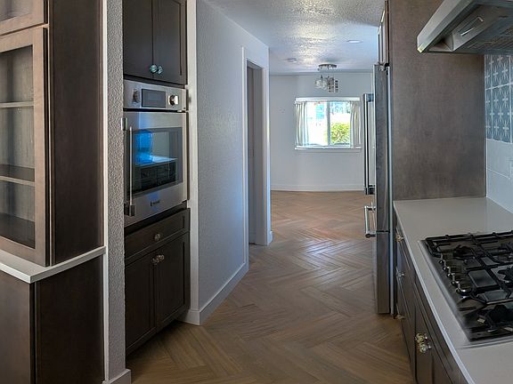 An L-shaped kitchen offers high-end. stainless steel appliances