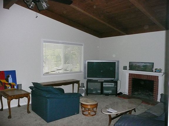Family rm with wood vaulted ceiling and wood burning fireplace