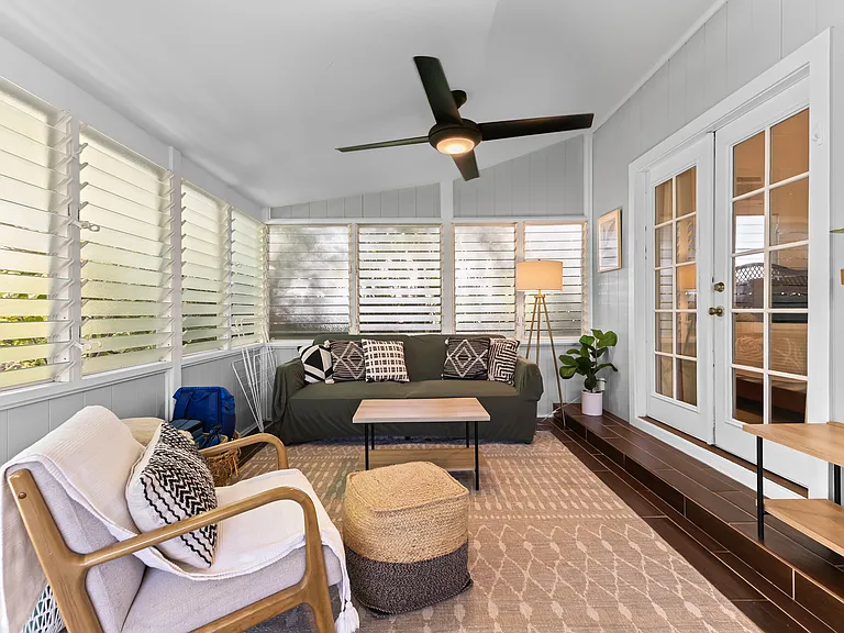 Enclosed lanai adds additional living space, a futon sofa, chair, TV, small dining set for 3-4, and a desk. Two large fans and lots of windows keep this area cool.