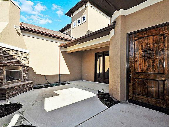 Entrance with courtyard includes a fireplace of stone and stucco.