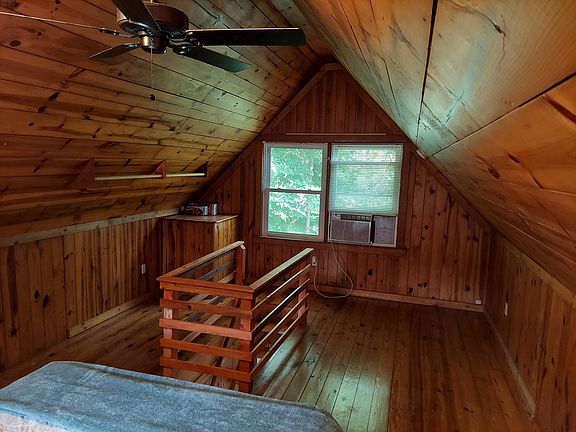 View of bedroom with window air conditioner and stairway to downstairs